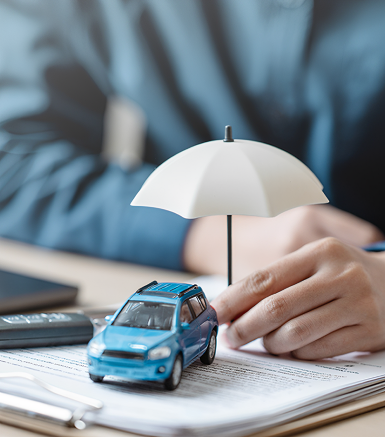 Miniature car under umbrella on document