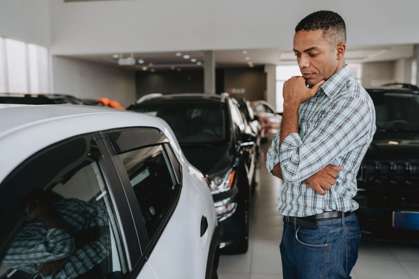 Man inspecting white car at dealership