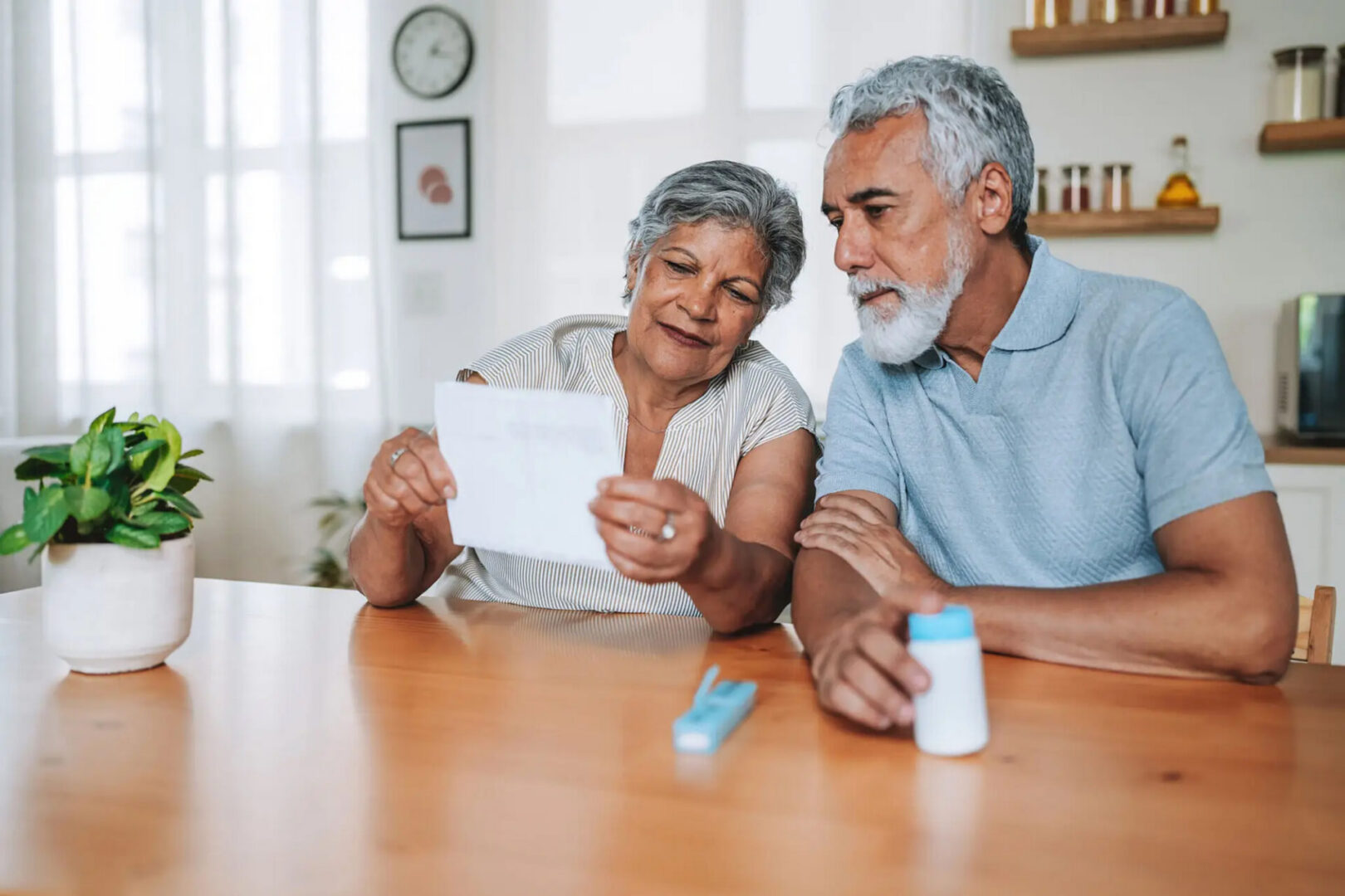 Senior couple reading prescription directions at kitchen table