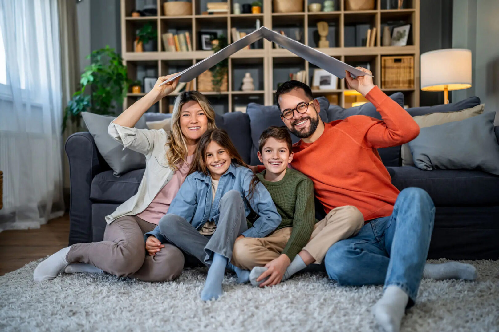 Smiling family under makeshift book roof