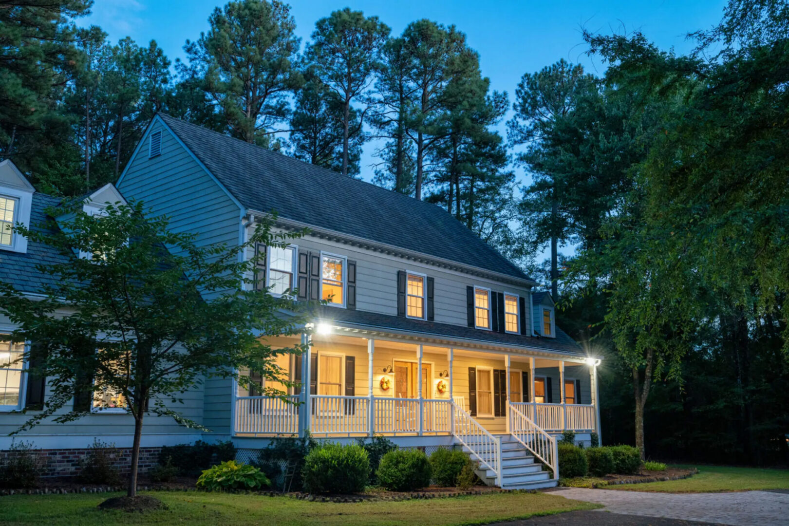 Large suburban house with lit front porch