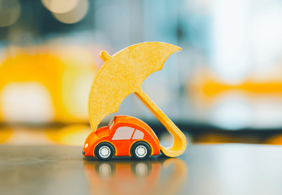 Red toy car under yellow umbrella